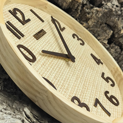 Detailaufnahme der Holzwerk SAARBURG 30 cm Wanduhr mit besonderem Augenmerk auf das besondere Rattan-Design mit braunen Zeigern