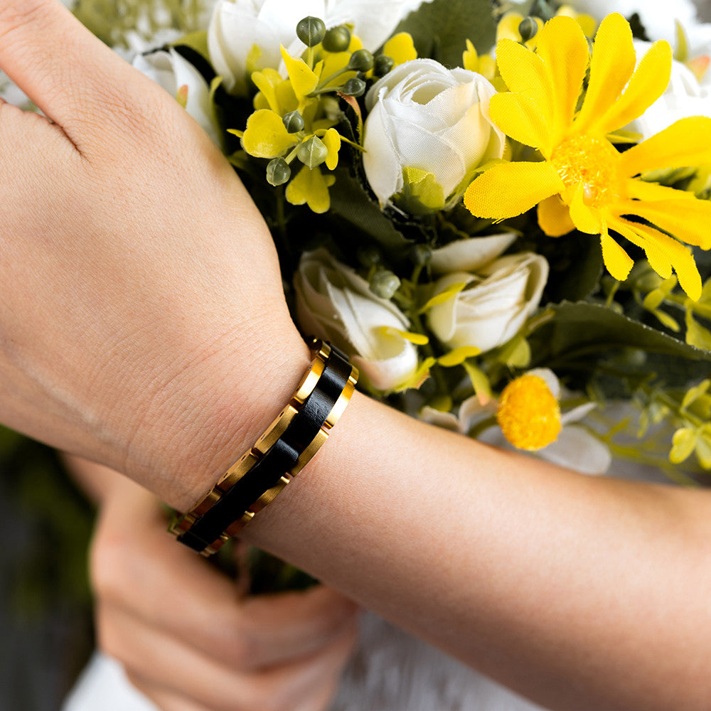 Holzwerk TEGERNSEE Damen und Herren Holz & Edelstahl Armband in gold, schwarz, Nahaufnahme von Oben auf linkes Handgelenk