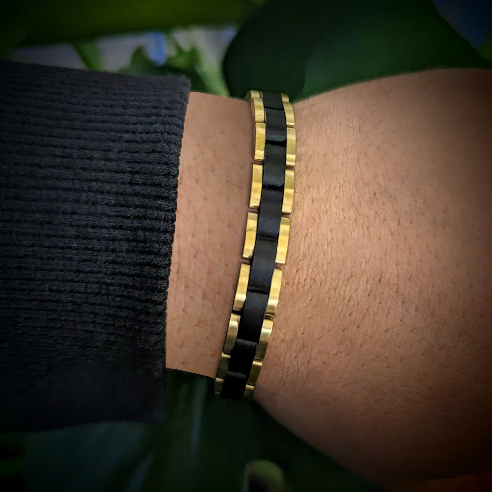 Holzwerk TEGERNSEE Damen und Herren Holz & Edelstahl Armband in gold, schwarz, Nahaufnahme von Oben auf linkes Handgelenk