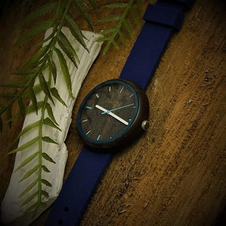 Holzwerk LAUBACH Damenuhr mit Holzgehäuse in Dunkelbraun sowie braunem Ziffernblatt und blauem Silikonarmband, seitlich auf Holz liegend